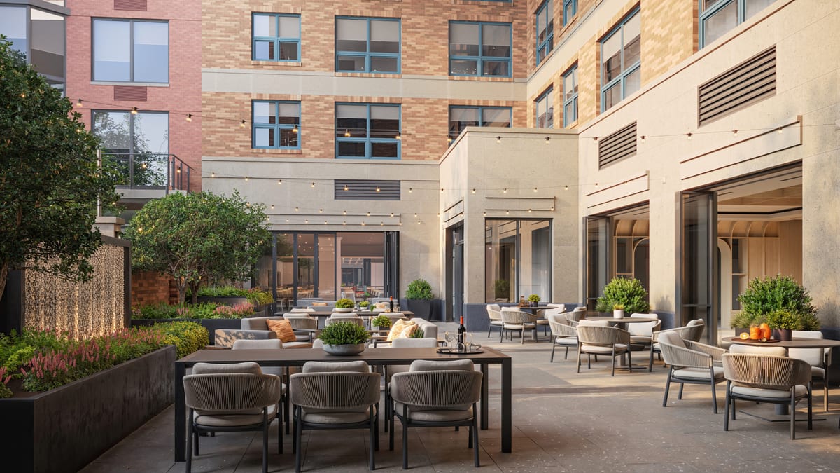Evening rendering of an amenity courtyard with outdoor lounge seating and a water feature
