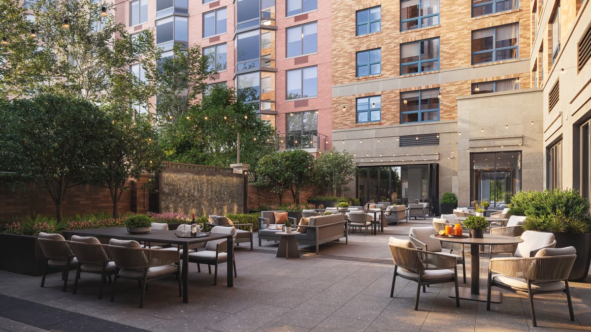 Rendering of a courtyard terrace with dining tables between residential buildings